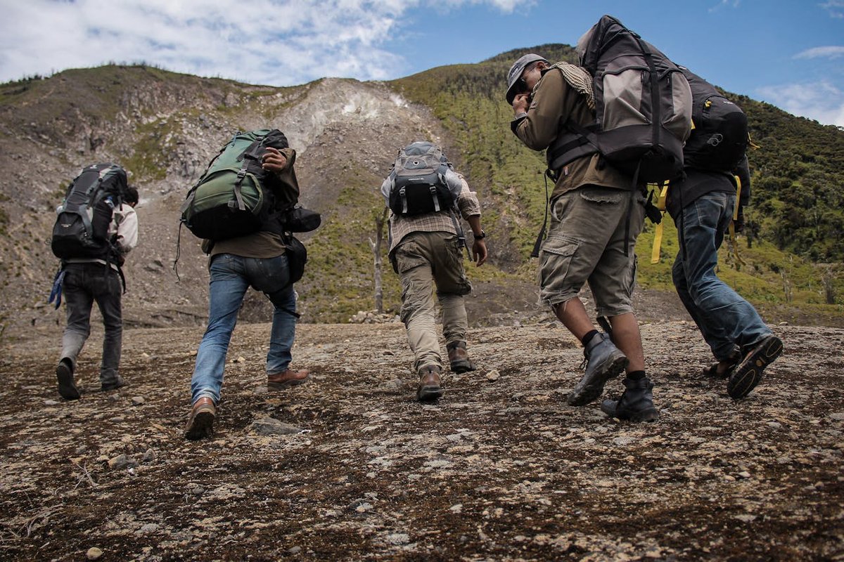 Un grupo de amigos sonriendo y haciendo senderismo por un sendero de montaña, disfrutando de la naturaleza y la compañía gracias a Afinexo